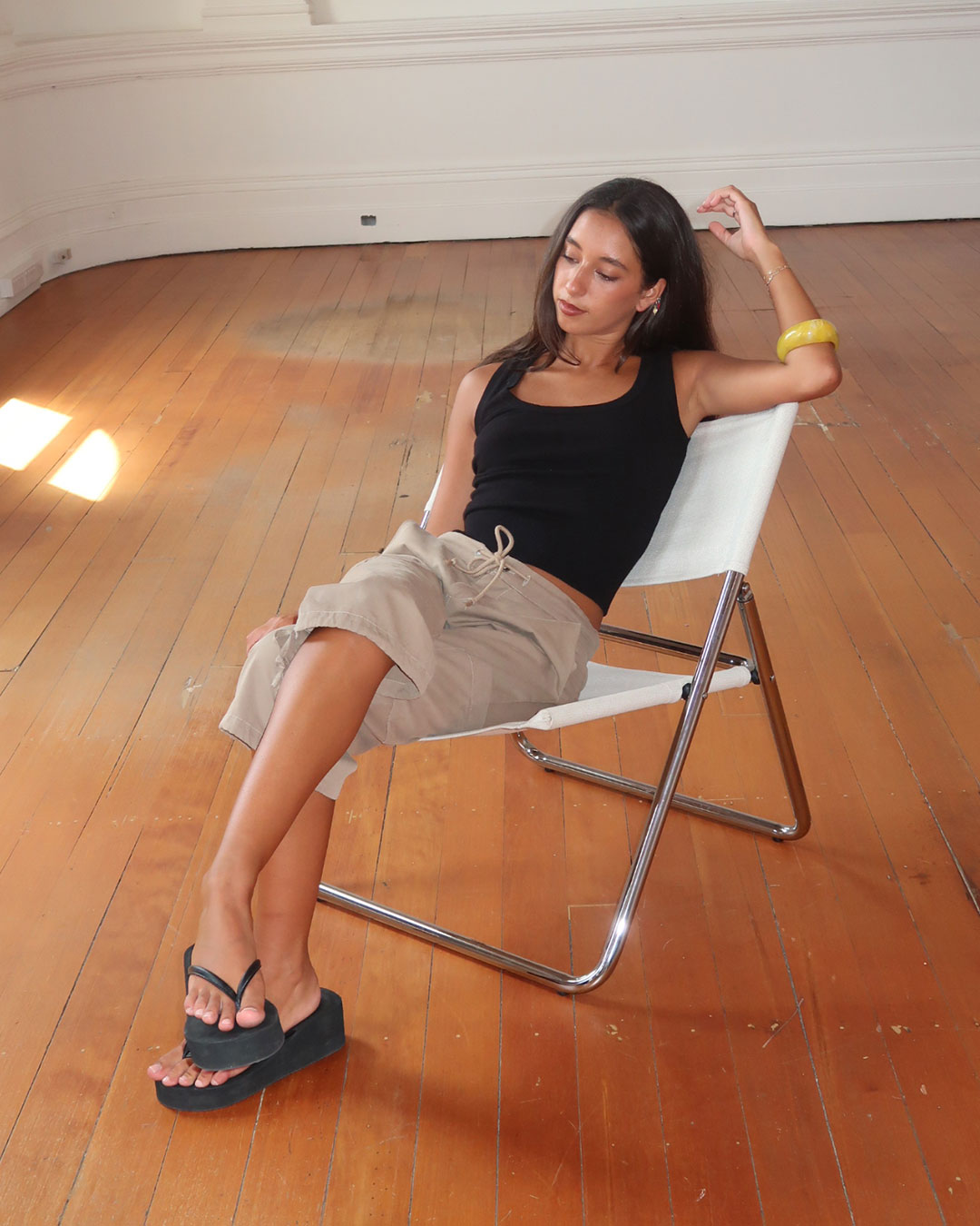 Women's black knit sleeveless top with scoop neck and cinched ribbed wasist band