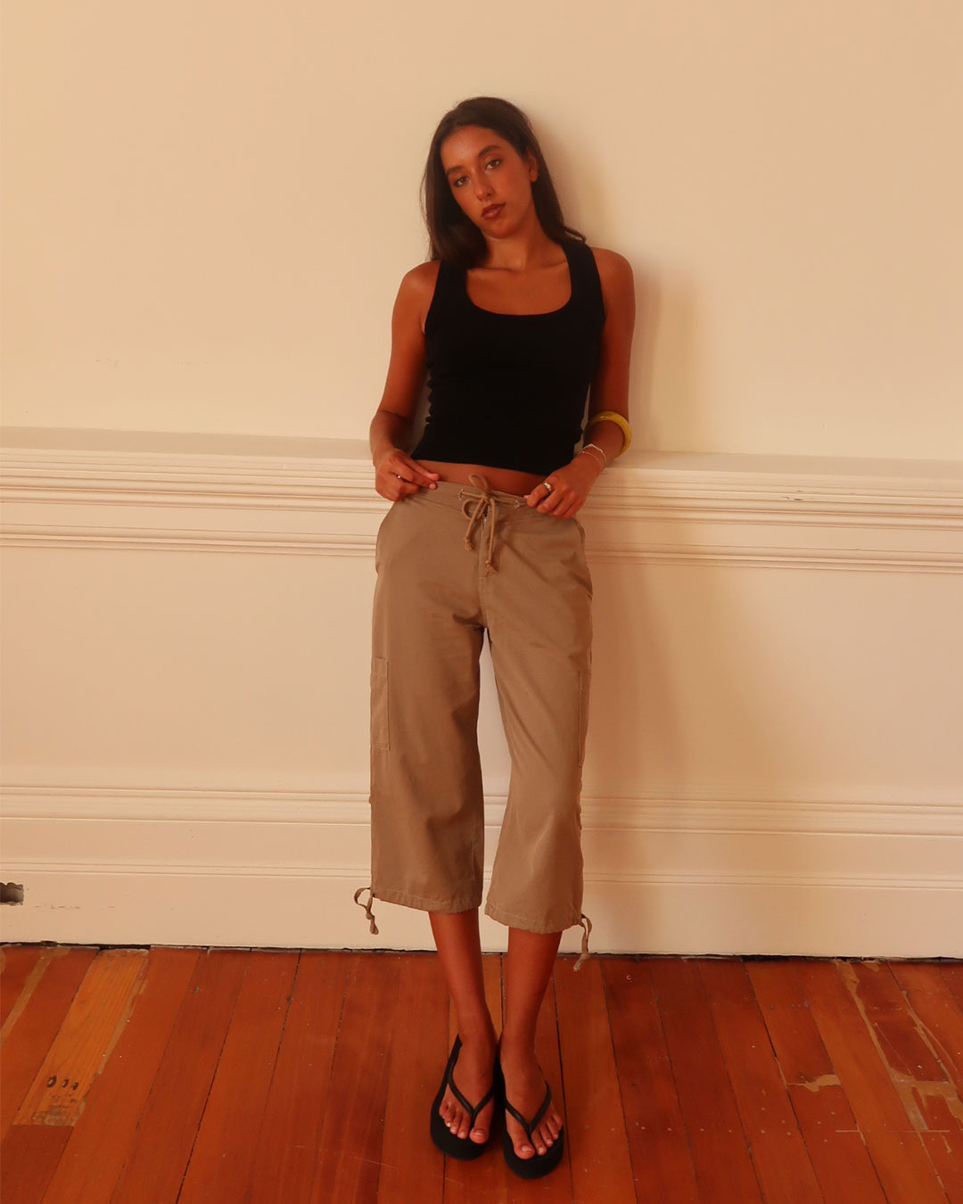 Women's black knit sleeveless top with scoop neck and cinched ribbed wasist band