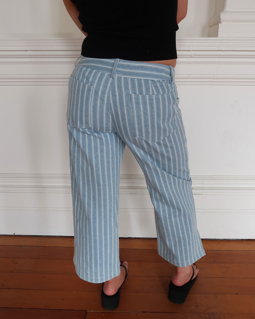Women's low waisted pant in denim stripe featuring 3/4 length and straight leg fit. 