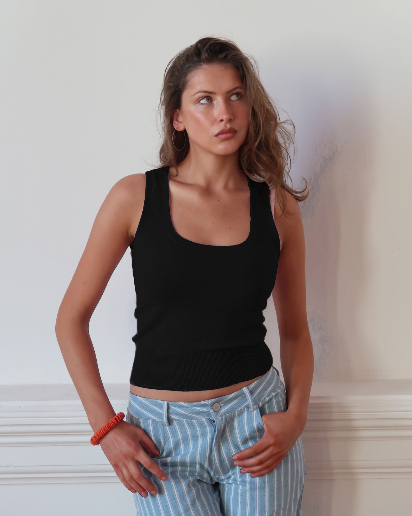 Women's black knit sleeveless top with scoop neck and cinched ribbed wasist band